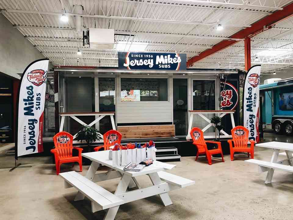 A customized tailgate trailer lets fans sample Jersey Mike’s subs.