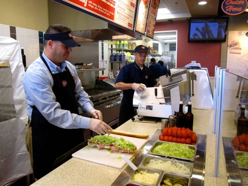 Jersey Mike's franchise owners Jeff Berns, left, and John Griparis prepare a giant Italian sub Sept. 6.